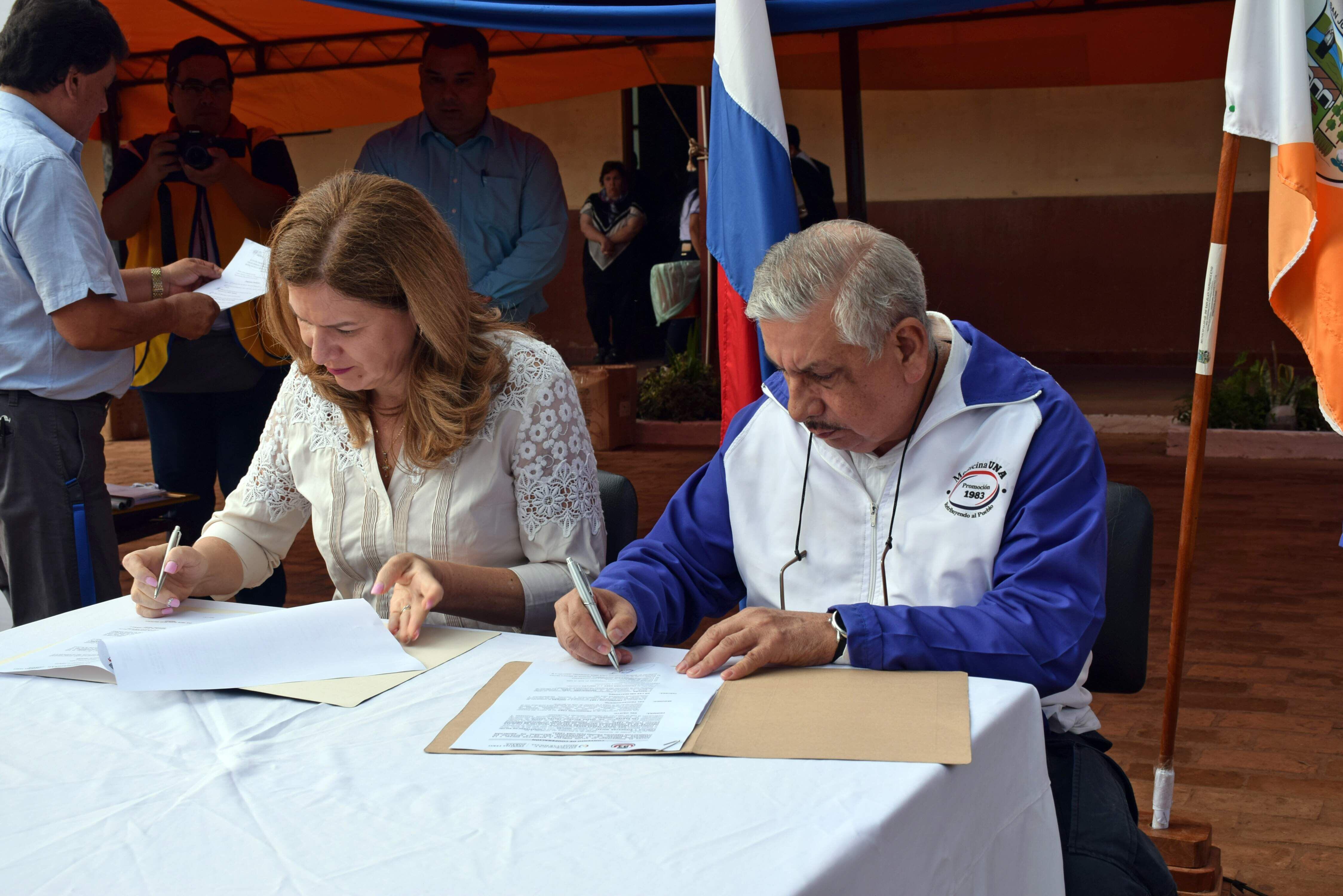 La ministra de Salud, María Teresa Barán, y el Dr. Isaías Fretes, de la Promo 83, firmando un convenio de cooperación.