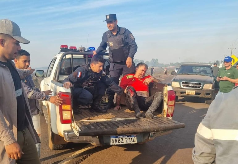 Efectivos policiales trasladan precariamente al herido Domingo Ramón Portillo, conductor de uno de los vehículos involucrados en el siniestro.