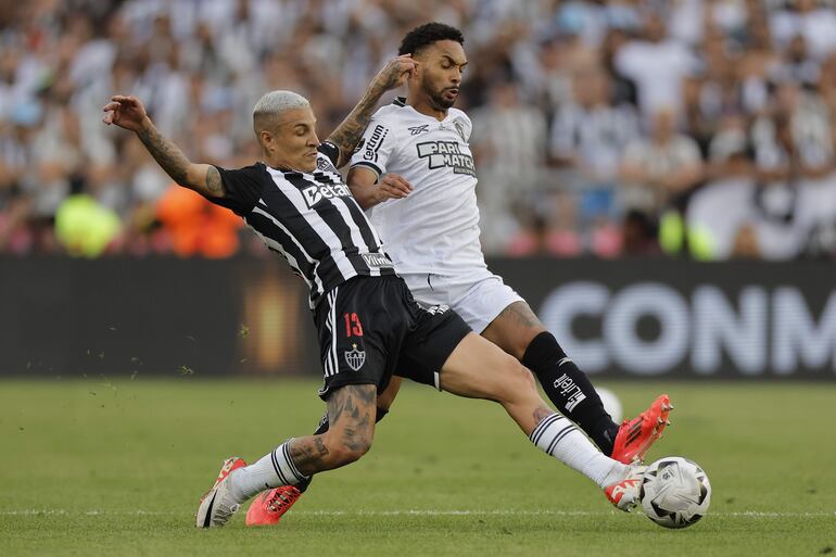 Guilherme Arana (i) de Mineiro disputa un balón con Vitinho de Botafogo este sábado, en la final de la Copa Libertadores entre Atlético Mineiro y Botafogo en el estadio Más Monumental en Buenos Aires (Argentina).