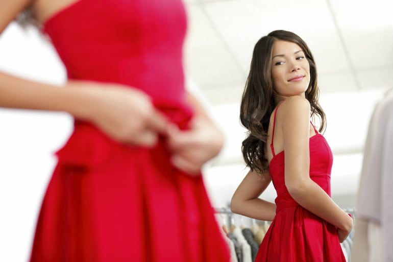 Mujer mirándose en el espejo, vestida de rojo