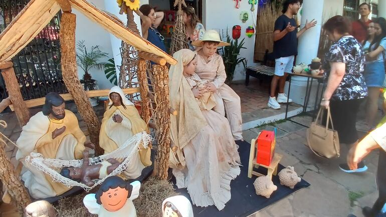 Dos niños representando pesebre viviente en la vereda de una galería