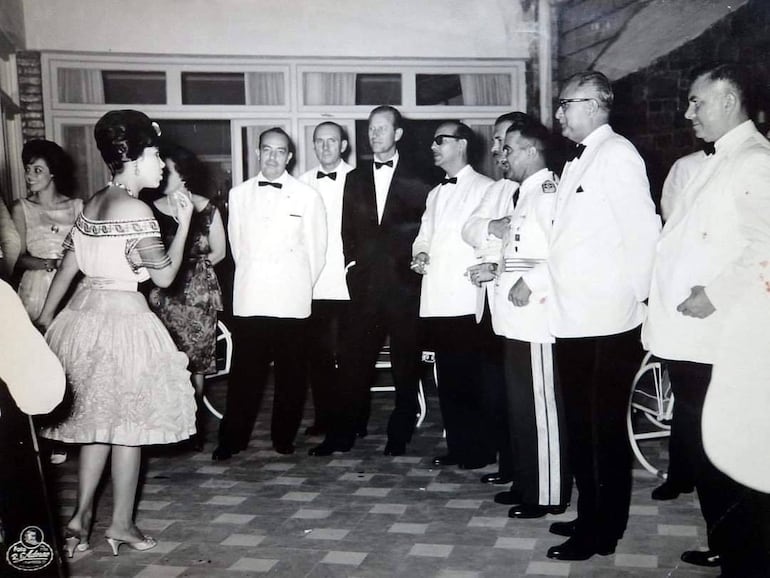 En 1973 Olinda Massare quedó al frente del Primer Curso Libre de Historia Nacional, cuya apertura estuvo a cargo de Dionisio González Torres. En esta foto vemos a González Torres con Sapena Pastor y el general César Barriento, entre otros, en la recepción del príncipe Felipe de Edimburgo en Asunción en 1962 (Archivo ABC Color).