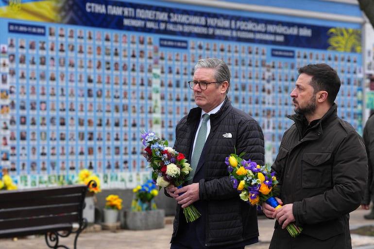 El primer ministro británico Keir Starmer (a la izquierda) y el presidente ucraniano Volodímir Zelenski llevan flores a un monumento a los caídos en la guerra con Rusia, este jueves en Kiev.