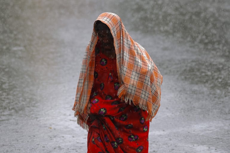 Una mujer camina bajo una fuerte lluvia en Bangalore, el pasado 15 de julio.