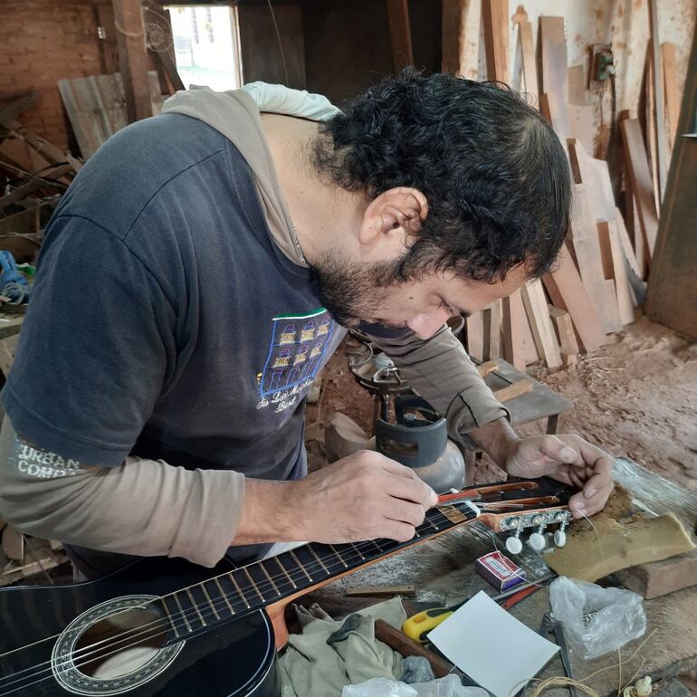 Denis López es el encargado de crear las más bellas guitarras en el taller de don Aurelio.