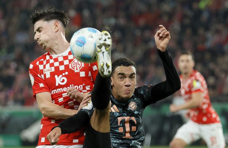 Mainz (Germany), 30/10/2024.- Anthony Caci of Mainz (L) in action against Jamal Musiala of Bayern (R) during the German DFB Cup second round soccer match between 1. FSV Mainz 05 and FC Bayern Munich in Mainz, Germany, 30 October 2024. (Alemania) EFE/EPA/RONALD WITTEK CONDITIONS - ATTENTION: The DFB regulations prohibit any use of photographs as image sequences and/or quasi-video.
