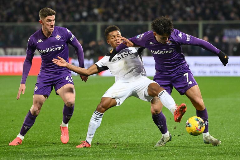 Napolis Brazilian forward #07 David Neres (C) fights for the ball with Fiorentinas Italian forward #07 Ricardo Sottil (R) and Fiorentina's German defender #21 Robin Gosens during the Italian Serie A football match Fiorentina against Napoli, at Artemio Franchi stadium, in Florence on January 4, 2025. (Photo by Alberto PIZZOLI / AFP)