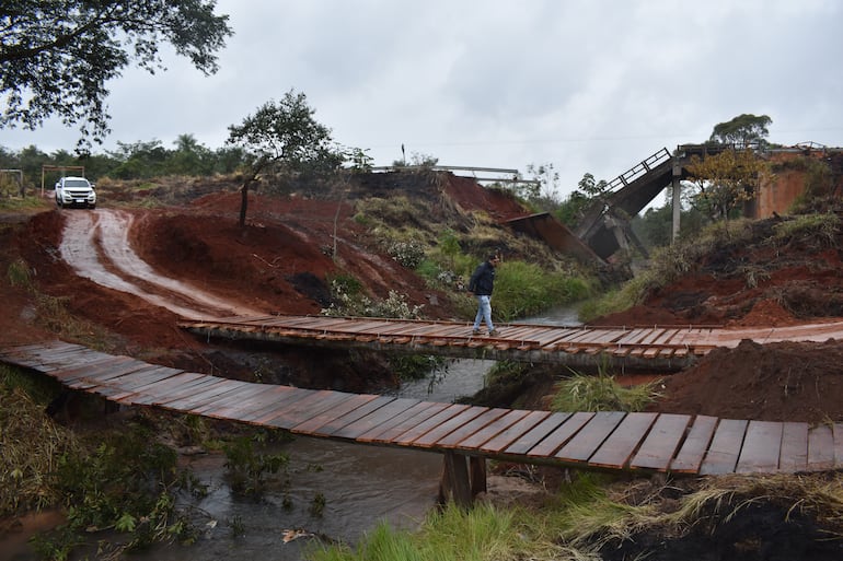 Pobladores de Tacuatí, con apoyo de colonos menonitas, construyeron un paso de madera. De fondo, el puente de concreto caído en junio pasado.