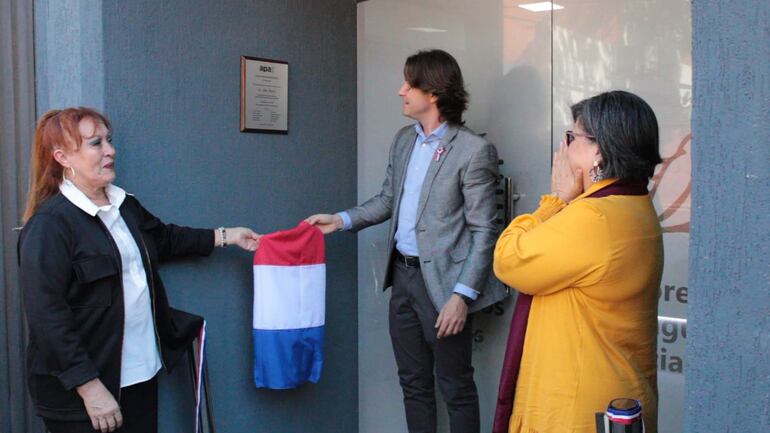 Momentos en que el presidente de Apa, David Portillo y la vicepresidenta del gremio, Lourdes Torres, descubren una placa recordatoria, ante el asombre de la principal benefactora, Lizza Bogado.