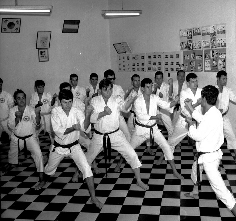 El profesor Carlos Valiente instruía en karate y artes marciales a los aficionados de esta nueva disciplina en el gimnasio Ajax.