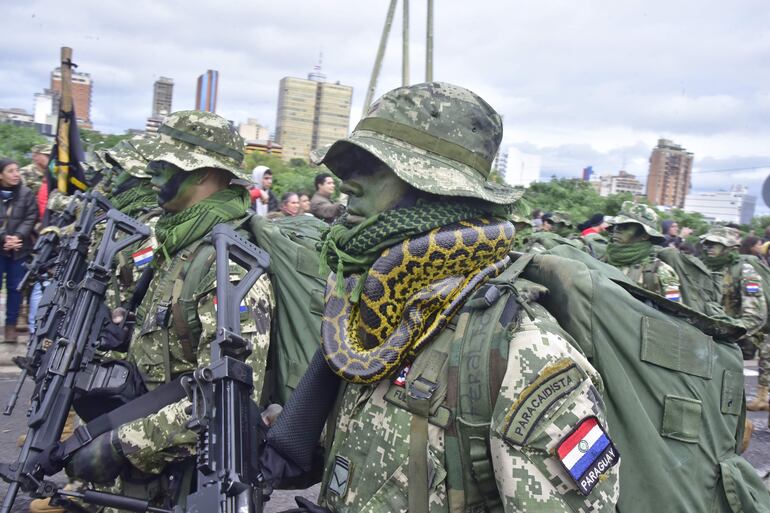 Un paracaidista exhibe una serpiente, durante el desfile militar y policial realizado en la Costanera de Asunción. 