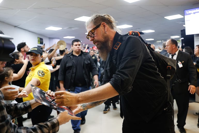 Jim Root, guitarrista de la banda estadounidense de metal alternativo Slipknot, firma autógrafos a su llegada al Aeropuerto Internacional Silvio Pettirossi este lunes en Luque (Paraguay).