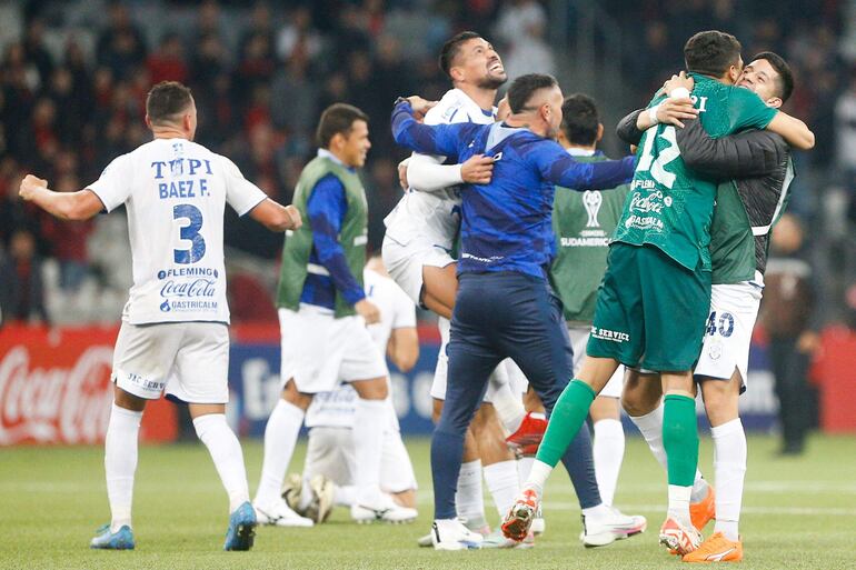 Los jugadores del Sportivo Ameliano celebran la victoria sobre Athetico Paranaense y clasificación a los octavos de final de la Copa Sudamericana 2024 en el Arena da Baixada, en Curitiba, Brasil.