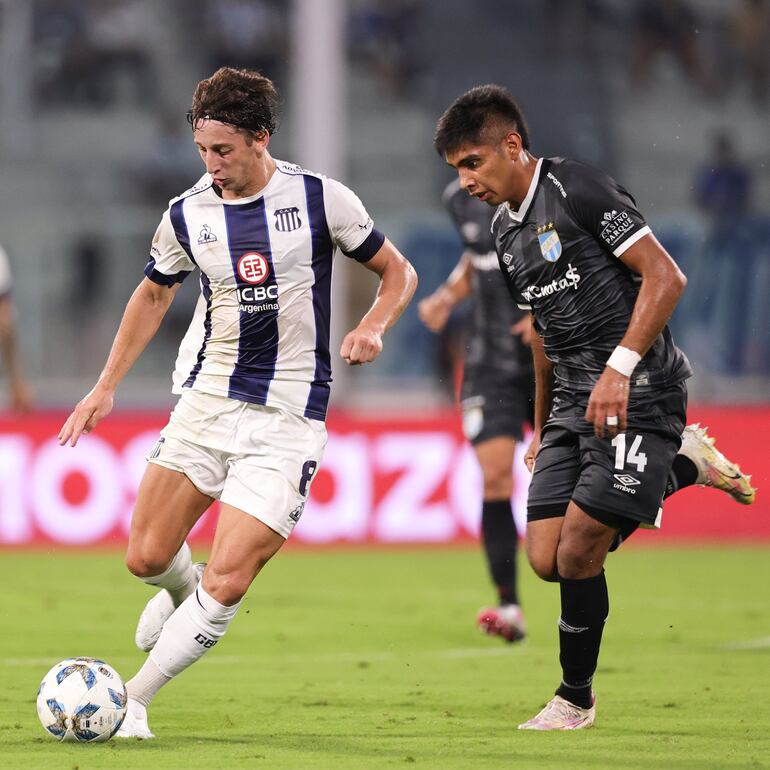 Matías Galarza se dispone a patear el balón ante la presencia de Agustín Lagos, defensor del Atlético Tucumán.