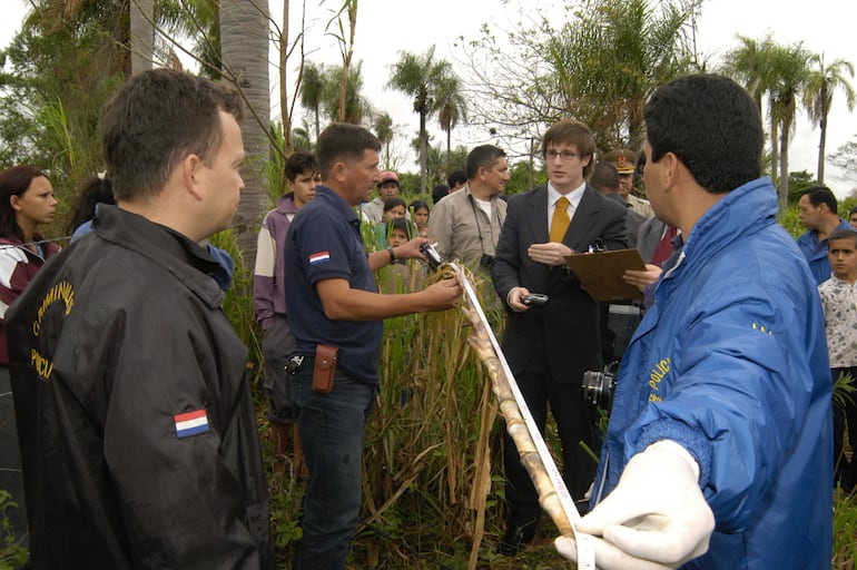 El ahora comisario general César Silguero (con campera negra) y el aún fiscal Rogelio Ortúzar (con traje), en el lugar donde tiraron al niño Amín Riquelme, en Luque. Fue el 13 de octubre de 2004.