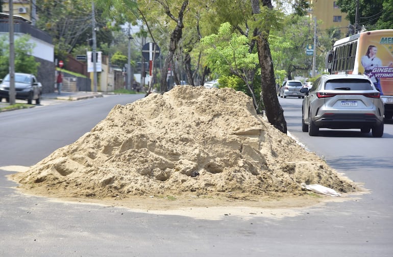 La arena que debería estar en contenedores protegida, está en pleno asfalto  y los autos circulan al lado.