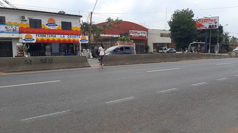 Los estudiantes juntos a los padres pasan por el angosto espacio habilitado entre cada separador.