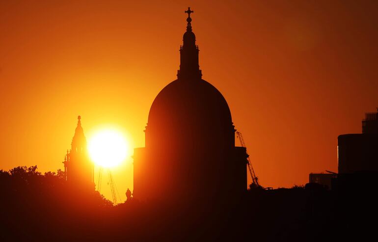 El sol se eleva por detrás de la cúpula de la catedral de San Pablo, en Londres, donde hoy se viven las temperaturas más elevadas del año.