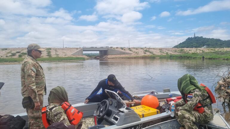 Los buzos argentinos ayudan en la búsqueda del militar desparecido tras ser arrastrado por el raudal.