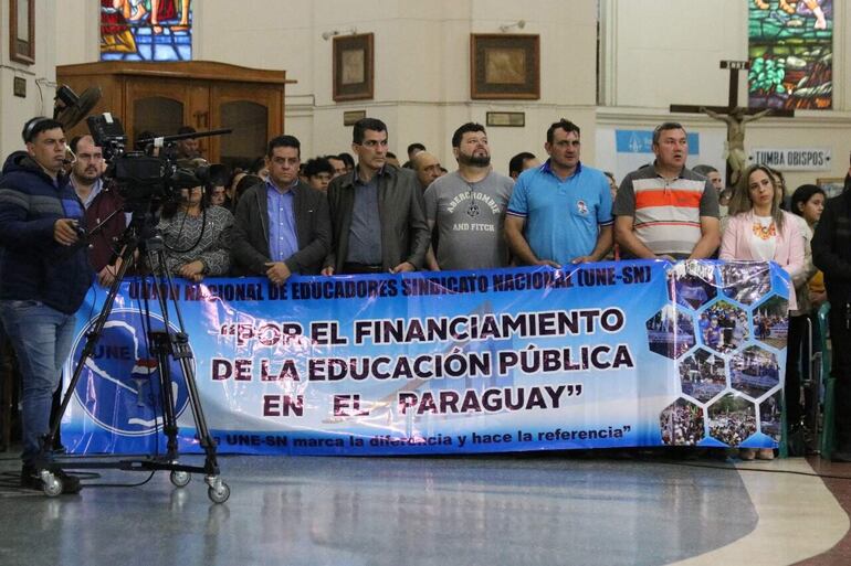 Docentes agremiados en la Unión de Educadores-Sindicato Nacional asistieron ayer a la misa dominical de las 07:00 en la Basílica de la Virgen de los Milagros de Caacupé.