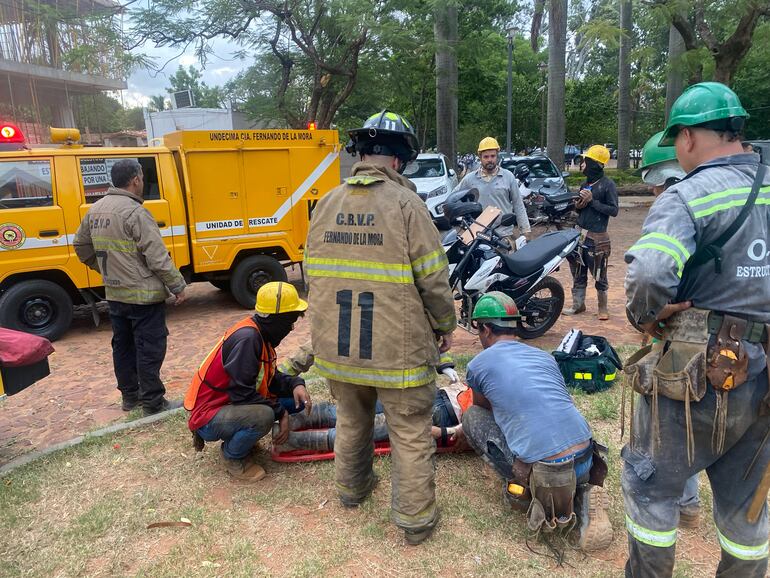 Bomberos asisten a una persona herida tras el derrumbe.