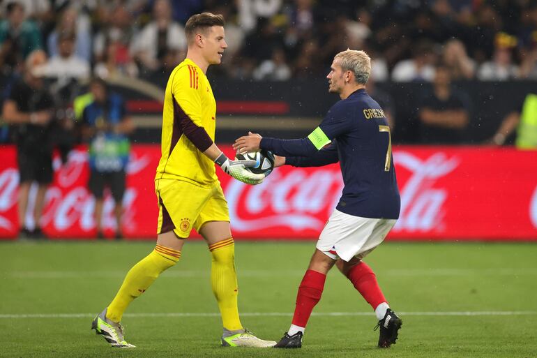 Antoine Griezmann (d) toma el balón del arquero alemán Marc-Andre ter Stegen, su ex compañero en el Barcelona, a quien batió ayer desde los doce pasos en el amistoso entre Alemania y Francia.