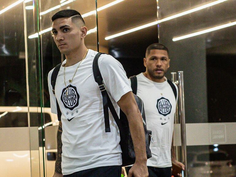 Hugo Fernández (i) y Richard Ortiz, jugadores de Olimpia, llegan al hotel de concentración en Ciudad del Este en la víspera del debut en el torneo Clausura 2024 del fútbol paraguayo.