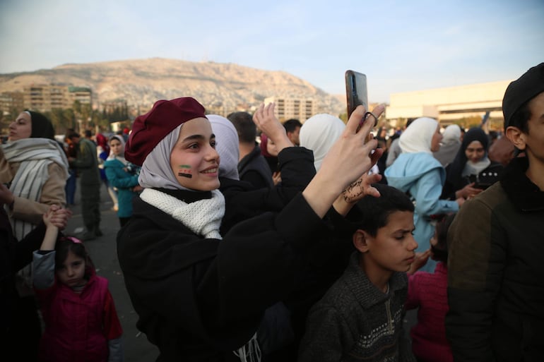 -FOTO DEL DÍA- Damasco (Siria), 09/12/2024.- Cientos de personas celebran el derrocamiento del presidente sirio al-Assad, en la plaza Omeya de Damasco, Siria, este lunes. Los rebeldes sirios entraron en Damasco el 8 de diciembre de 2024 y anunciaron en una declaración televisada la "liberación de la ciudad de Damasco y el derrocamiento de Bashar al-Assad', así como la liberación de todos los prisioneros. EFE/BILAL AL HAMMOUD
