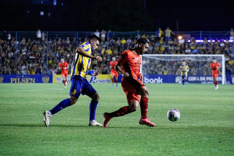 Diego Duarte (d), jugador de Nacional, domina la pelota en un partido frente a Sportivo Luqueño por la fecha 16 del torneo Clausura 2024 del fútbol paraguayo en el estadio Conmebol, en Luque.