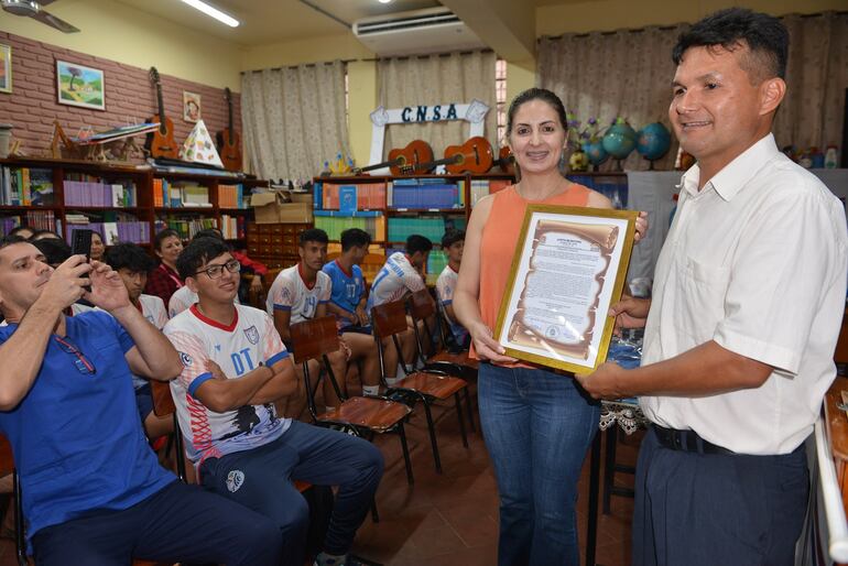 La  concejal Alison Anisimoff hace entrega de la resolución de Junta Municipal que declara de interés municipal la participación del  equipo en el torneo internacional. 