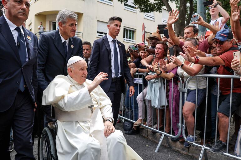 El papa Francisco saluda a la gente congregada para saludarlo luego de reunirse con el primer ministro portugués en la nunciatura apostólica de Lisboa.