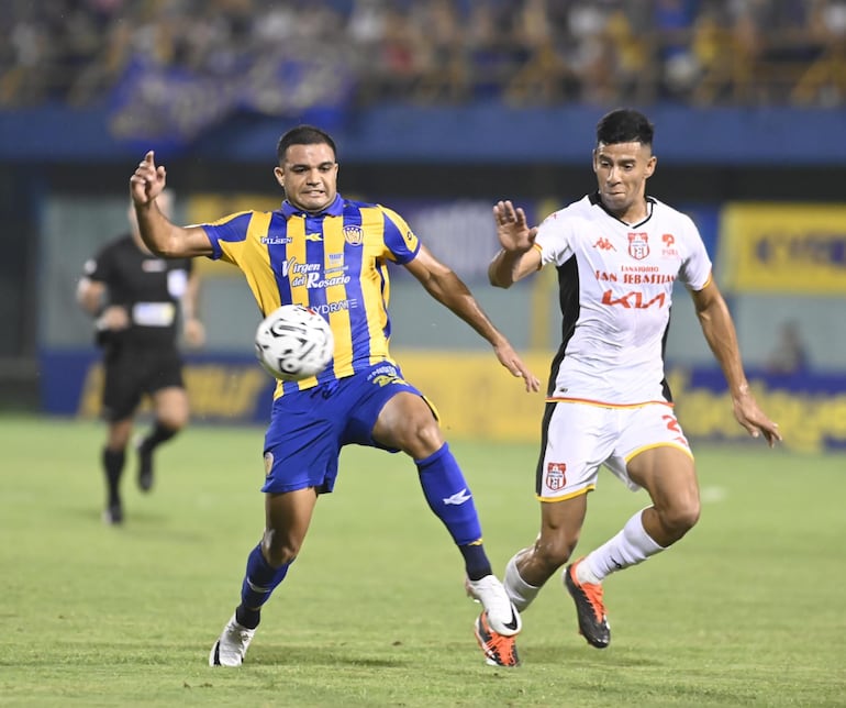 Marcelo Ferreira (Luqueño) pelea el balón con Ever Fernández (General Caballero JLM).