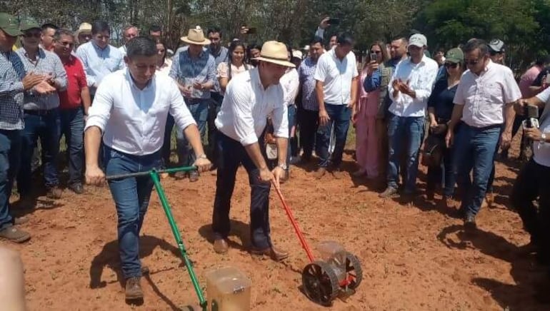 El ministro Carlos Giménez y el presidente de La Cámara de Exportadores de Sésamo Gilberto Ozorio realizan una siembra en una sembradora a mano simbólica en el predio del acto de lanzamiento