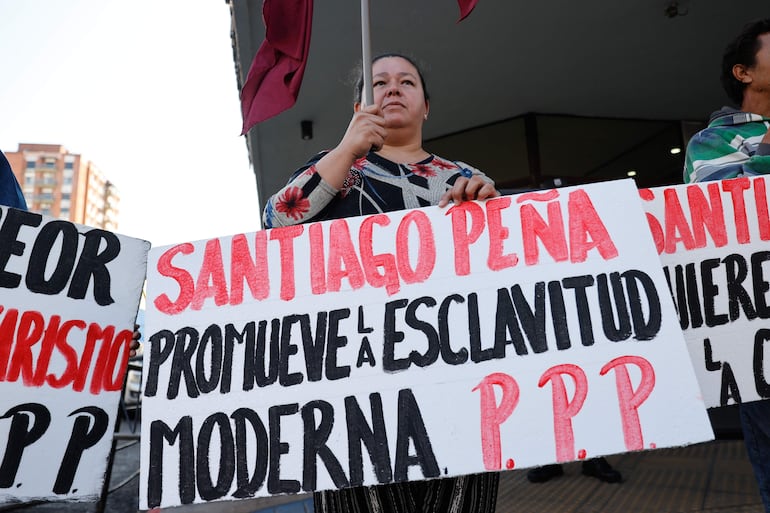 Integrantes del partido político Paraguay Pyahura realizan una manifestación a las afueras del Ministerio de Trabajo, Empleo y Seguridad Social, este lunes, en el centro de Asunción. Manifestantes aseguraron estar en desacuerdo con un proyecto de ley impulsado por el presidente Santiago Peña que modificaría el Código Laboral vigente en la nación, y que afectaría la estabilidad laboral.