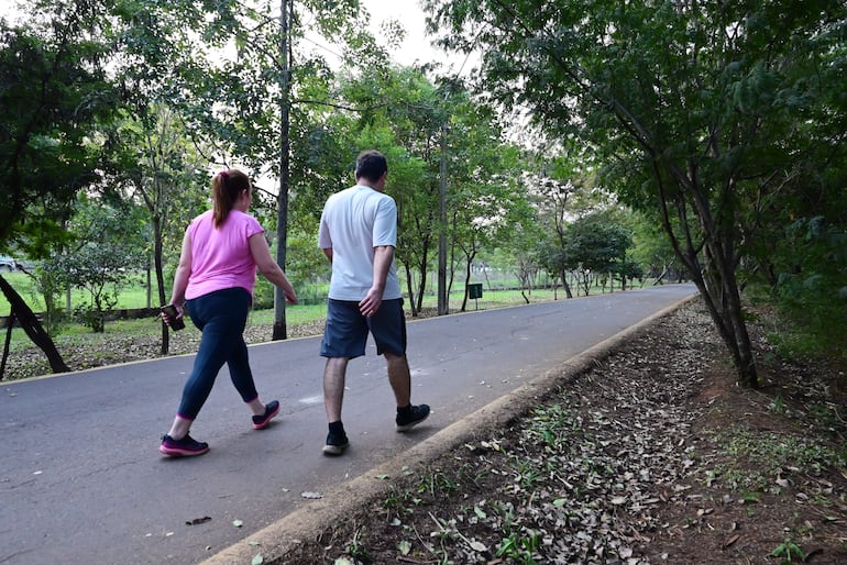 Dos personas caminan en el Parque Guasú.