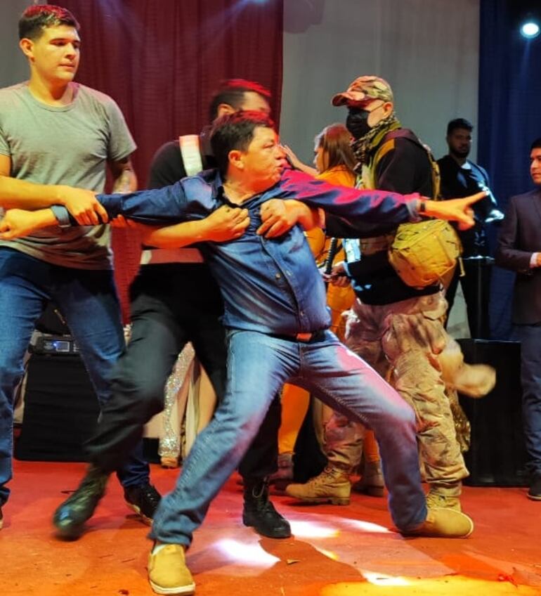 Claudio Santacruz, padre de la candidata Aramí Santacruz, es contenido por un guardia de seguridad en el escenario de la elección de Miss Guarambaré, luego de que supiera que su hija perdiera la elección.