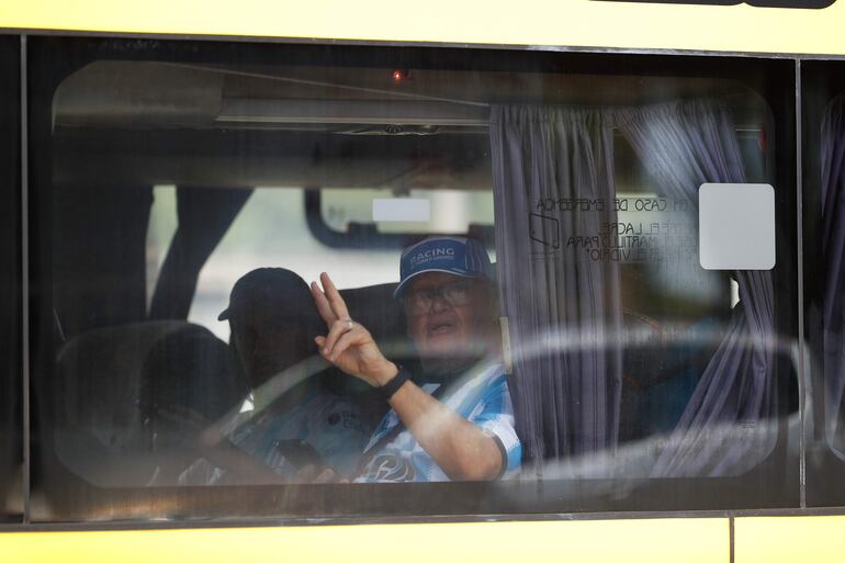 Un hincha de Racing saluda desde un ómnibus al llegar a la Estación de Buses