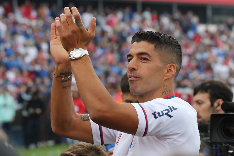 AME6578. BOGOTÁ (COLOMBIA), 22/12/2023.- Fotografía de archivo del futbolista uruguayo Luis Suárez saludando a los aficionados del Club Nacional, el 31 de agosto de 2023, en el estadio Gran Parque Central en Montevideo (Uruguay). El Inter Miami anunció este viernes el fichaje de Luis Suárez, que en su desembarco en la MLS se reunirá con su amigo Leo Messi tras brillar juntos en el Barcelona. El atacante uruguayo, de 36 años, también se reencontrará en Florida con otros dos ilustres excompañeros del club culé: Sergio Busquets y Jordi Alba. EFE/ Raúl Martínez ARCHIVO
