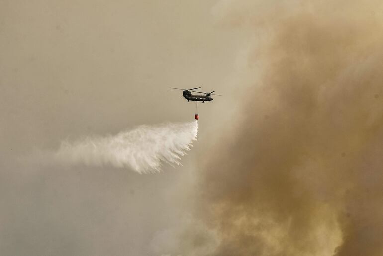 Un helicóptero arroja agua sobre un incendio forestal cerca de Atenas, Grecia, este martes.
