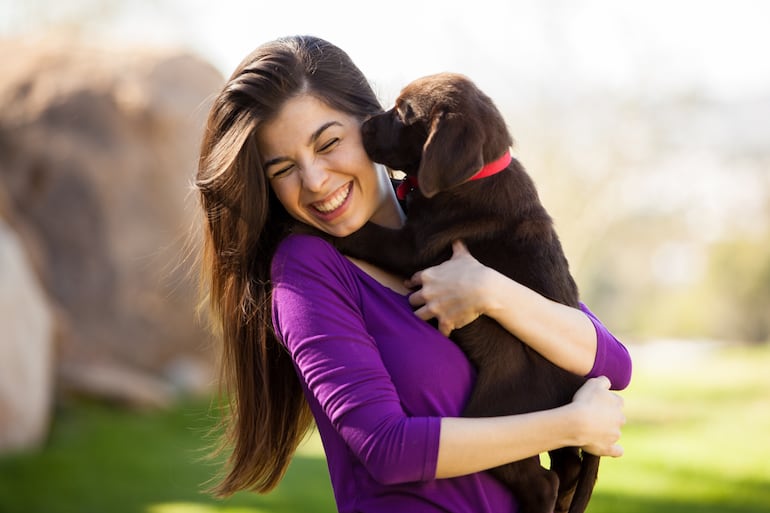 Una joven interactúa con un cachorro.