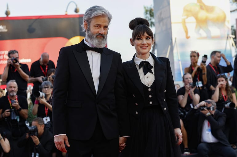 La famosa actriz Winona Ryder y Scott Mackinlay Hahn, de la manito en la red carpet del Festival de Cine de Venecia. (EFE/EPA/FABIO FRUSTACI)
