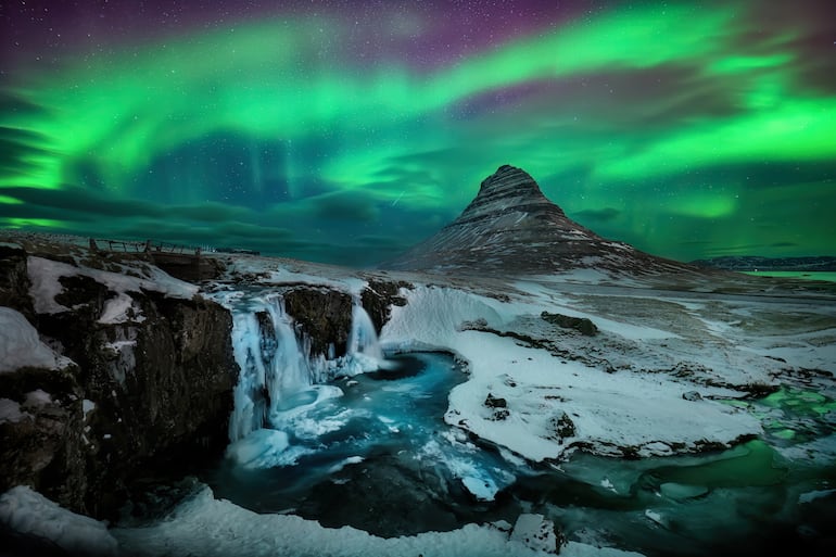 Aurora boreal sobre la montaña Kirkjufell en Islandia.