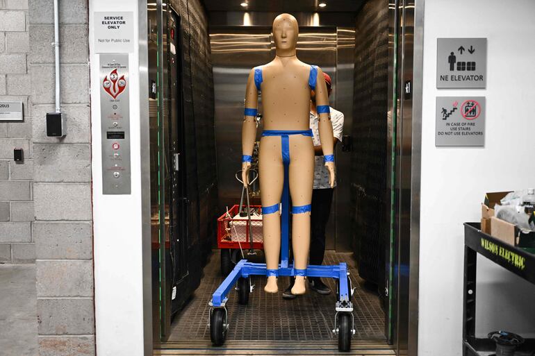 Ankit Joshi transporta ANDI, un instrumento dinámico avanzado de Newton, desde un ascensor fuera del laboratorio y en el campo mientras los investigadores preparan un experimento de calor y viento para aprender más sobre el efecto de la exposición al calor en el cuerpo humano en la Universidad Estatal de Arizona (ASU) durante una ola de calor récord en Phoenix, Arizona, el 20 de julio de 2023.  