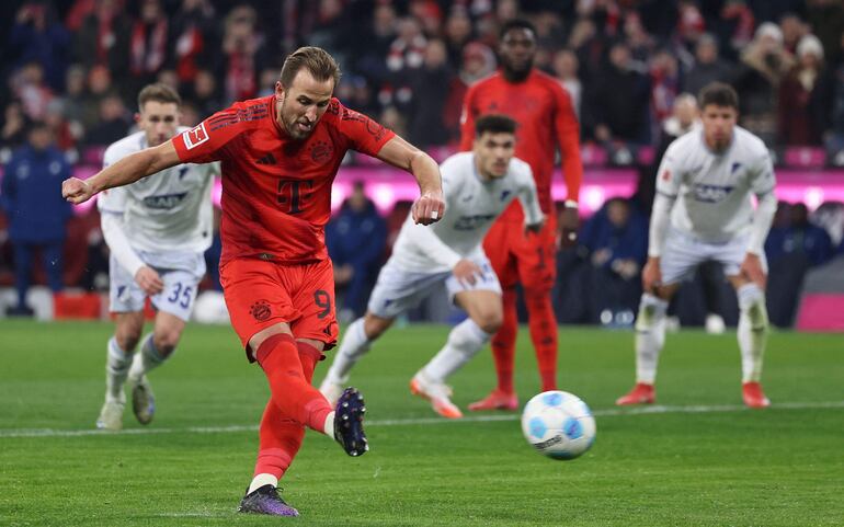 Bayern Munich's English forward #09 Harry Kane shoots and scores a goal during the German first division Bundesliga football match between FC Bayern Munich and TSG Hoffenheim in Munich on January 15, 2025. (Photo by Alexandra BEIER / AFP) / DFL REGULATIONS PROHIBIT ANY USE OF PHOTOGRAPHS AS IMAGE SEQUENCES AND/OR QUASI-VIDEO