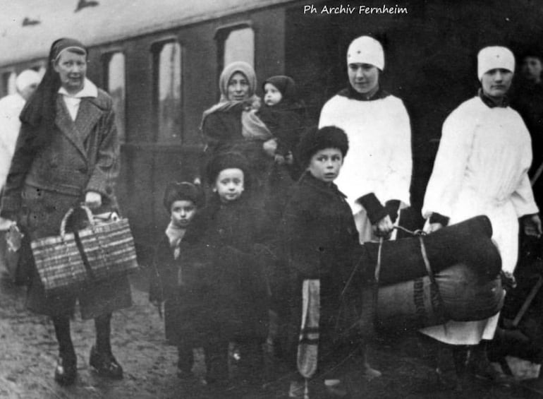 Refugiados en Letonia, después de cruzar el "Portal de la Libertad". En la fotografía se aprecia que llevaban apenas lo que podían cargar, también aparecen en la instantánea dos enfermeras, posiblemente parte de la Cruz Roja.