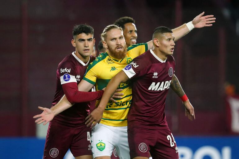 Cuiaba's Paraguayan forward Isidro Pitta (C) gestures amid Lanus' Uruguayan defender Gonzalo Perez (L) and Paraguayan defender Juan Caceres eyes the ball during the Copa Sudamericana group stage second leg football match between Argentina's Lanus and Brazil's Cuiaba at the Ciudad de Lanus stadium in Buenos Aires on May 29, 2024. (Photo by MARCOS BRINDICCI / AFP)