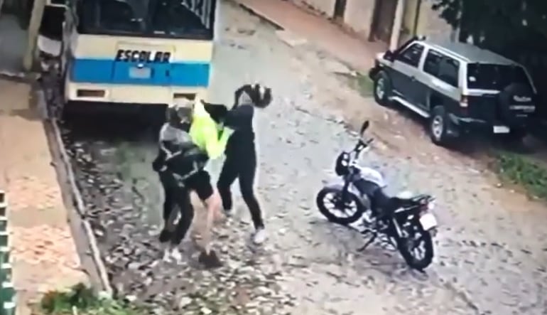 El joven, vestido con remera color fosforecente, peleando con los motochorros.