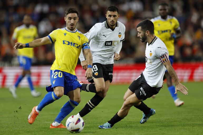 El centrocampista del Cádiz, Iza Carcelén (i), disputa el balón ante el defensa del Valencia, Gayá, durante el encuentro correspondiente a la jornada 10 de primera división que disputan hoy lunes en el estadio de Mestalla, en Valencia.