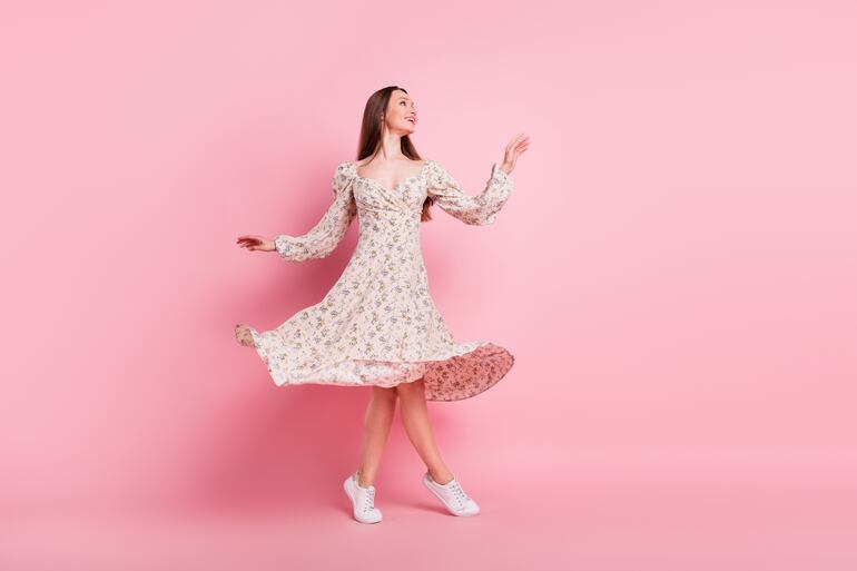 Una mujer joven con un vestido rosado.