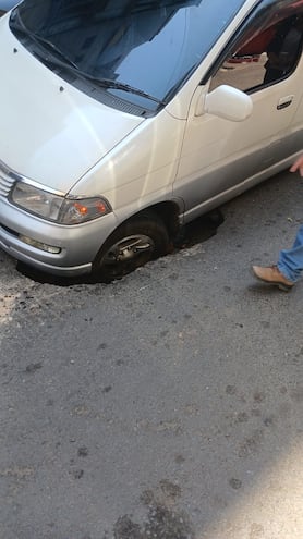 Rueda de una camioneta de gran porte quedó atrapada en un pozo que se abrió en la capa asfáltica de la calle Oliva de Asunción.